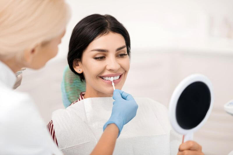 Women decides types of dental veneers in dental clinic Turkey